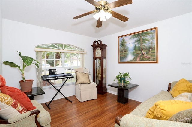 living room featuring dark wood-type flooring and ceiling fan