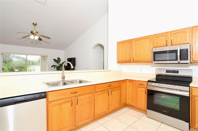 kitchen featuring appliances with stainless steel finishes, sink, ceiling fan, high vaulted ceiling, and light tile patterned floors