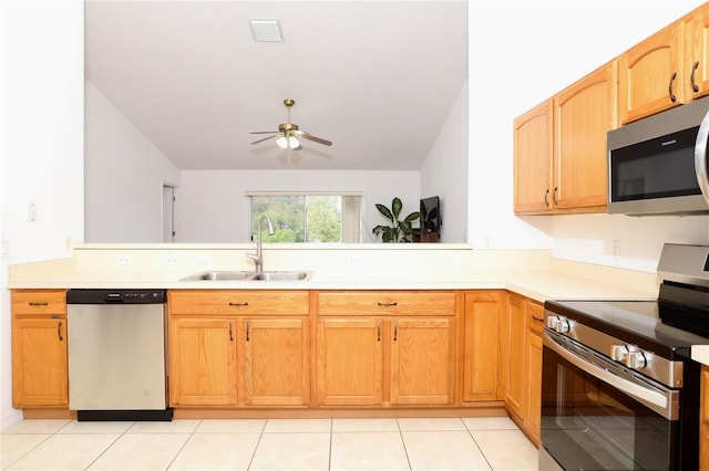 kitchen featuring light tile patterned floors, lofted ceiling, appliances with stainless steel finishes, and sink