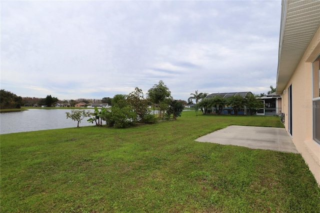 view of yard with a patio, a water view, and glass enclosure