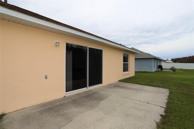 view of side of property featuring a patio area and a yard