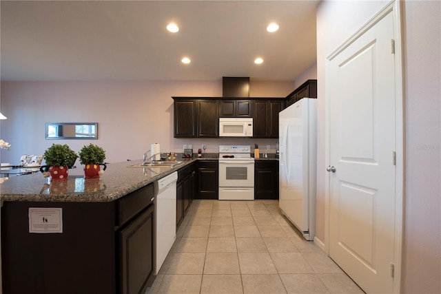 3171 Tocoa Cir, Kissimmee, FL 34746 - kitchen featuring white appliances, a sink, light tile patterned flooring, dark stone countertops, and dark brown cabinets