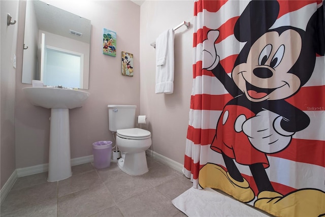 bathroom with toilet and tile patterned floors