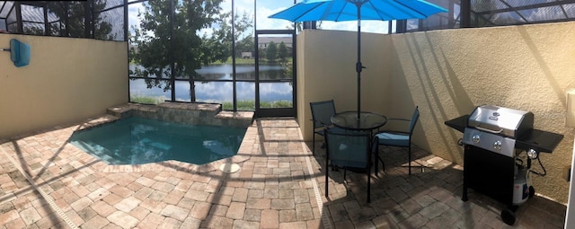 view of pool with area for grilling, a water view, a patio, and glass enclosure