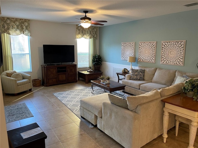 tiled living room with a textured ceiling and ceiling fan