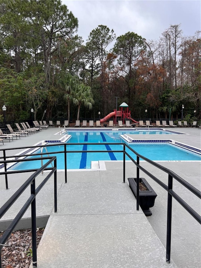 view of swimming pool with a playground