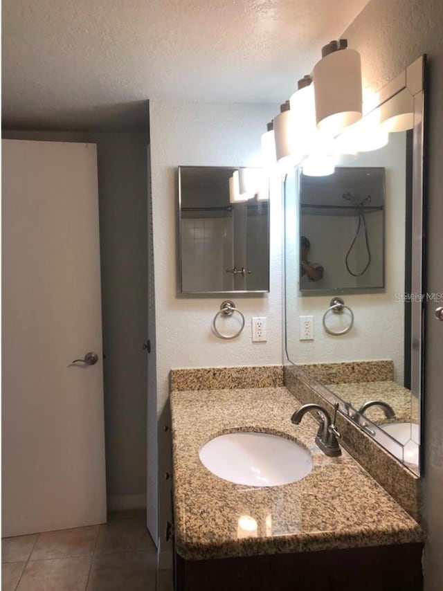 bathroom featuring tile patterned floors, a textured ceiling, and vanity