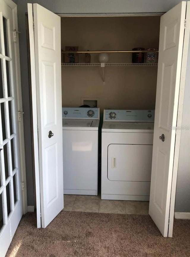 clothes washing area with separate washer and dryer and light colored carpet