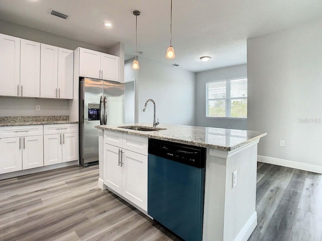 kitchen featuring appliances with stainless steel finishes, light hardwood / wood-style floors, white cabinetry, and an island with sink