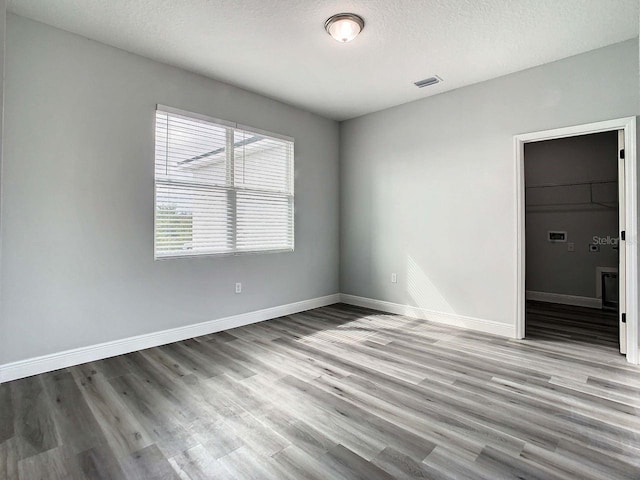 empty room with hardwood / wood-style flooring and a textured ceiling