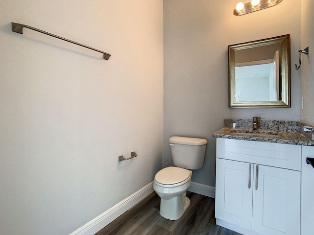 bathroom featuring wood-type flooring, vanity, and toilet