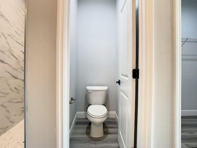 bathroom featuring hardwood / wood-style flooring and toilet