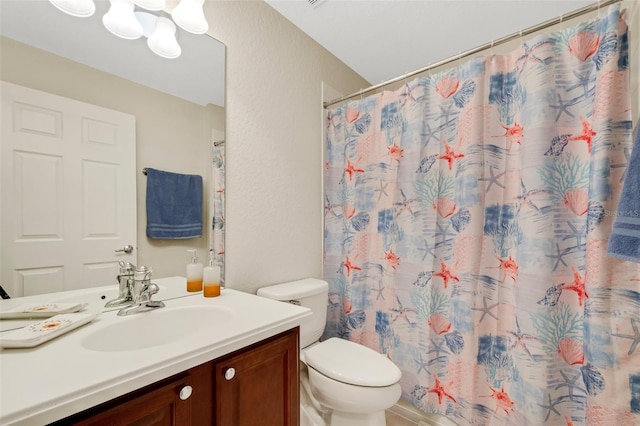 bathroom with toilet and vanity with extensive cabinet space