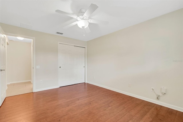 unfurnished bedroom featuring a closet, ceiling fan, and wood-type flooring