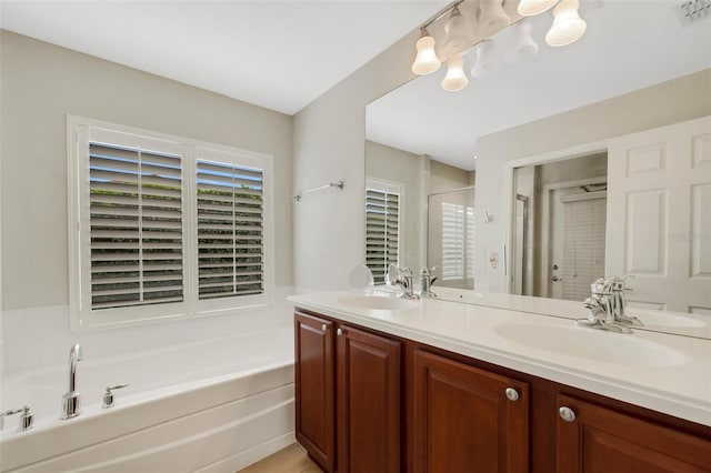 bathroom with dual bowl vanity and a bathtub