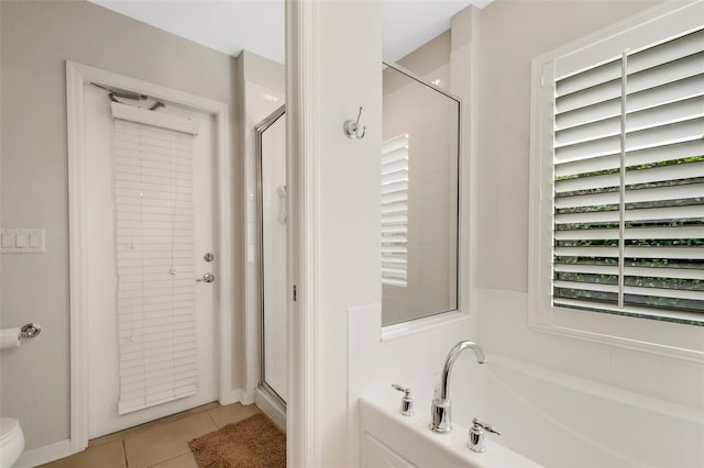 bathroom with tile flooring, a shower with shower door, and toilet