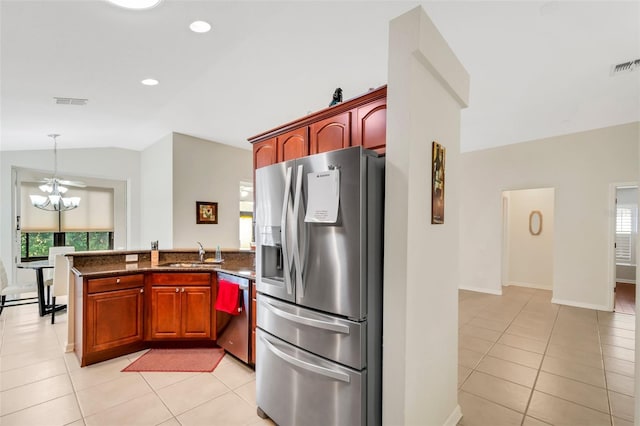 kitchen with sink, hanging light fixtures, stainless steel appliances, light tile flooring, and vaulted ceiling