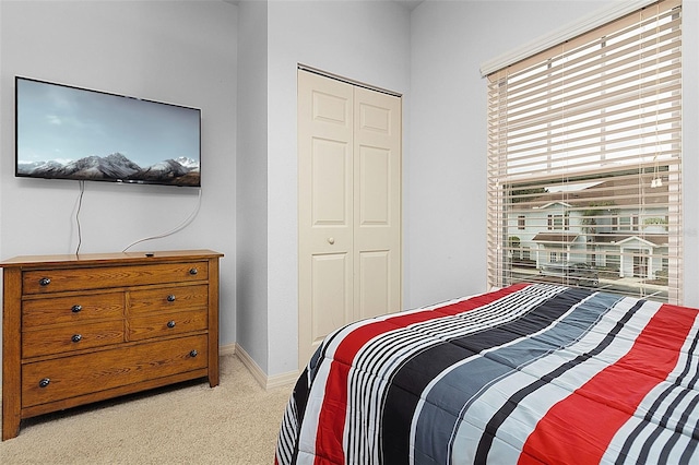 bedroom featuring light carpet, a closet, and multiple windows