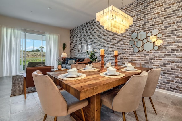 tiled dining space featuring brick wall and a notable chandelier