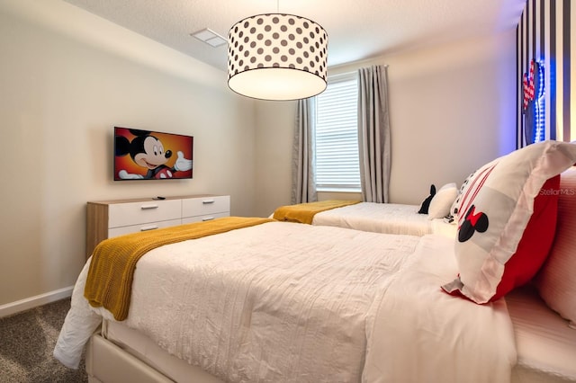 bedroom featuring a textured ceiling and dark colored carpet