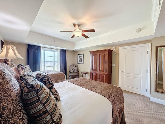 carpeted bedroom with a raised ceiling, ceiling fan, and ornamental molding