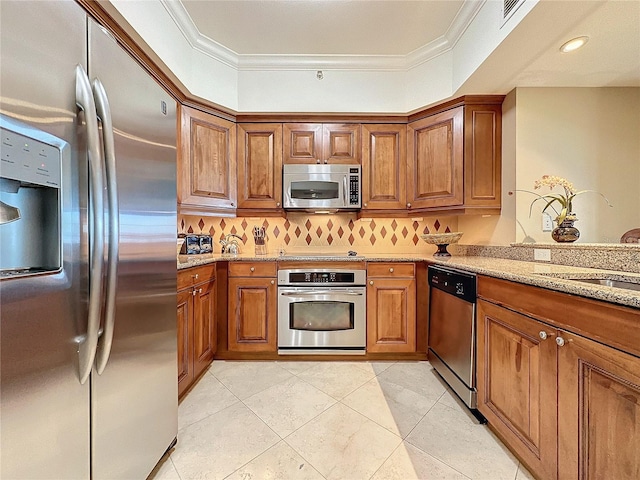 kitchen with light stone countertops, appliances with stainless steel finishes, backsplash, ornamental molding, and light tile patterned floors