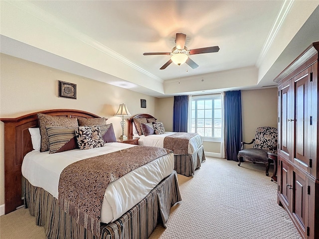 bedroom featuring ceiling fan, a raised ceiling, light colored carpet, and crown molding