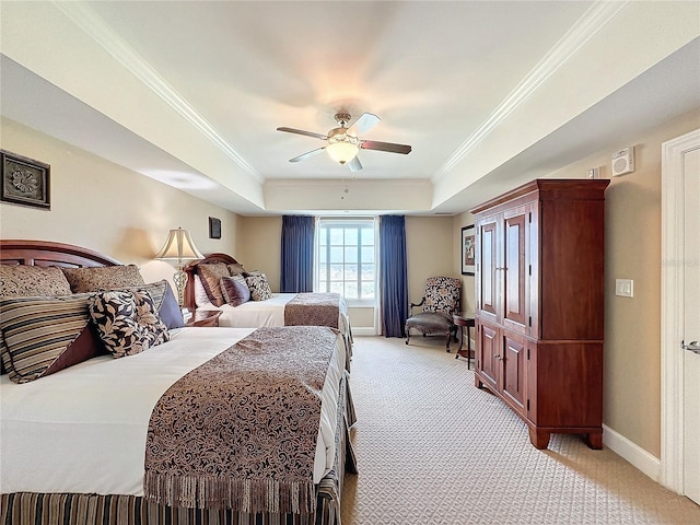 carpeted bedroom with a raised ceiling, ceiling fan, and ornamental molding