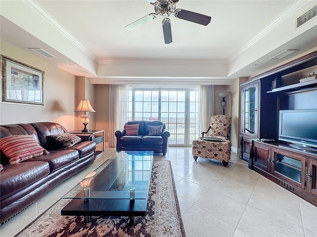 living room with tile patterned floors, a raised ceiling, ceiling fan, and ornamental molding