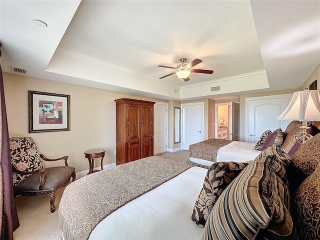 bedroom with ceiling fan and a raised ceiling