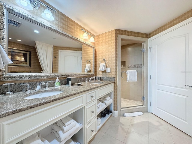 bathroom with tile patterned flooring, vanity, and walk in shower