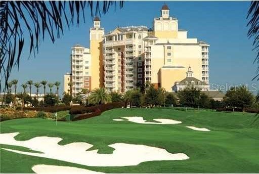 view of home's community featuring golf course view and a yard