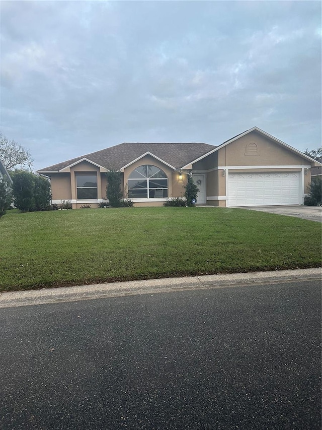 view of front of home with a front yard and a garage