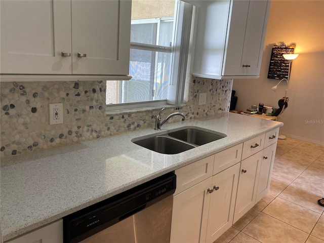 kitchen featuring tasteful backsplash, white cabinetry, sink, dishwasher, and light stone counters