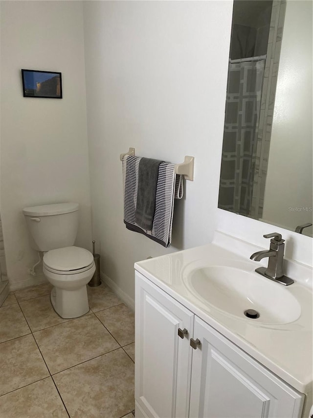 bathroom with toilet, tile floors, and large vanity