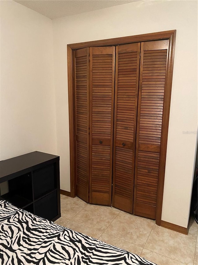 tiled bedroom featuring a closet