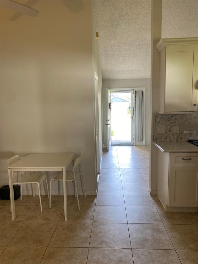 hallway with light tile floors and a textured ceiling