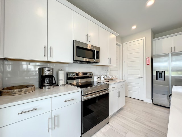 kitchen featuring backsplash, appliances with stainless steel finishes, and white cabinetry