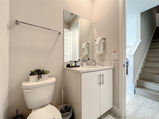 bathroom with tile floors, vanity with extensive cabinet space, and toilet