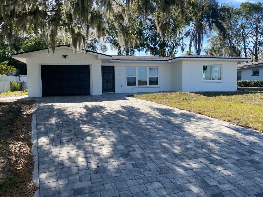 1204 Lake Elbert Dr SE, Winter Haven, FL 33880 - ranch-style house with fence, a garage, a front lawn, and decorative driveway