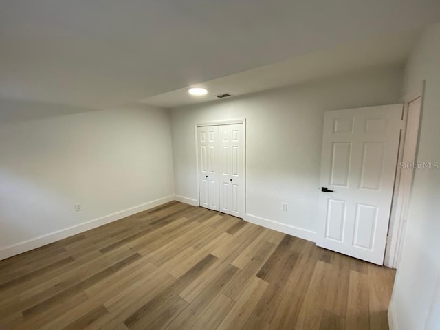 unfurnished bedroom with a closet and wood-type flooring