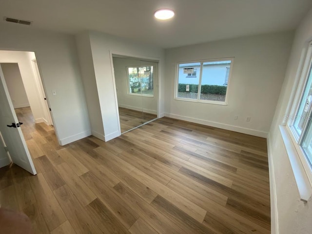 unfurnished bedroom with a closet and light wood-type flooring