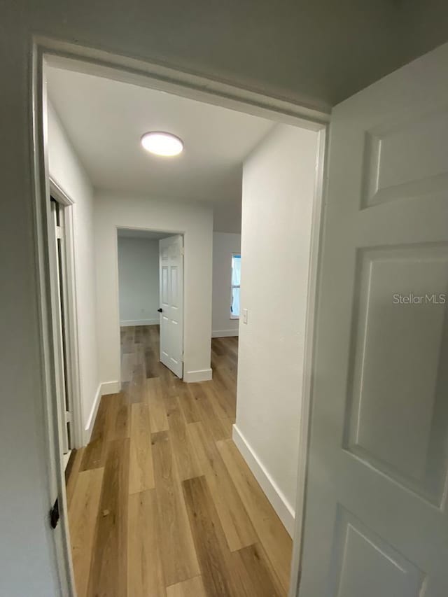 hallway with light hardwood / wood-style flooring