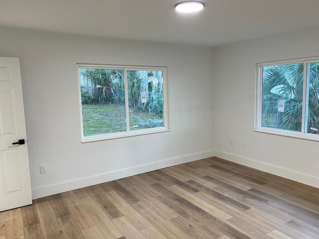 spare room with a wealth of natural light and light wood-type flooring