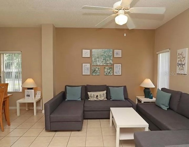 living room with light tile patterned flooring, a textured ceiling, and ceiling fan