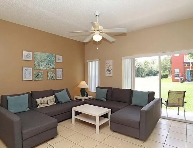 living room with a textured ceiling, a ceiling fan, and light tile patterned flooring