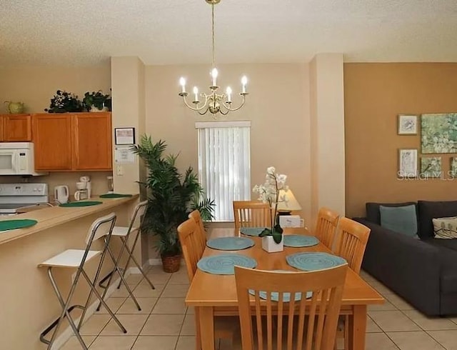 dining space with a textured ceiling, light tile patterned flooring, and an inviting chandelier