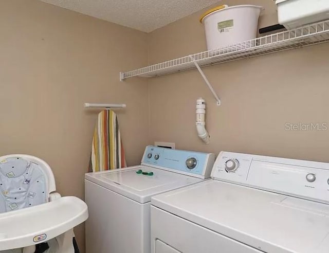 laundry room featuring a textured ceiling, laundry area, and separate washer and dryer