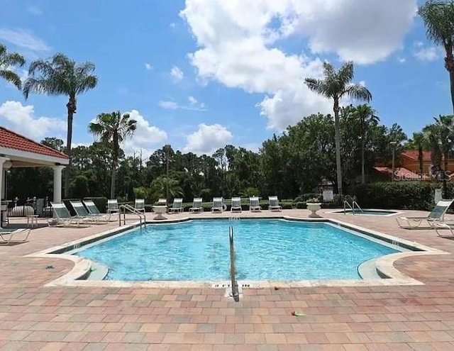 community pool featuring a patio and a hot tub