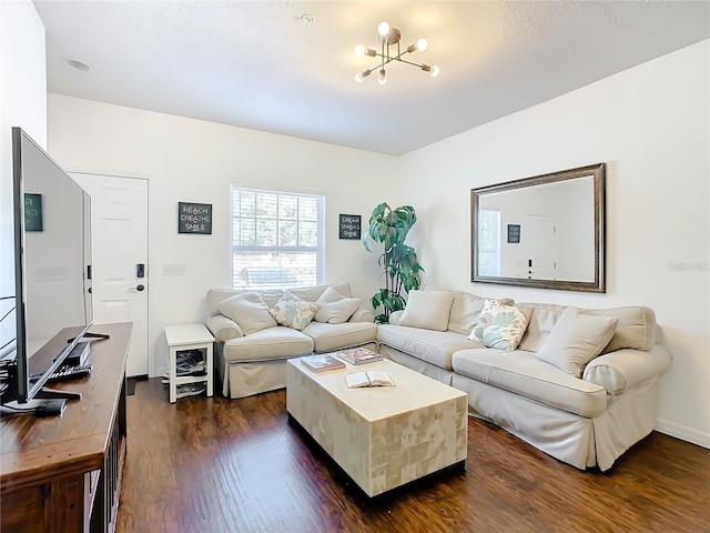 living room with a chandelier and dark wood-type flooring